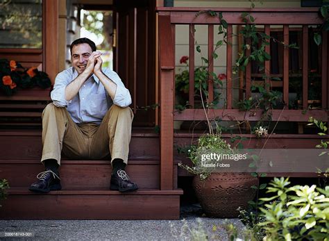 Young Man Sitting On Porch Steps Laughing Portrait High Res Stock Photo