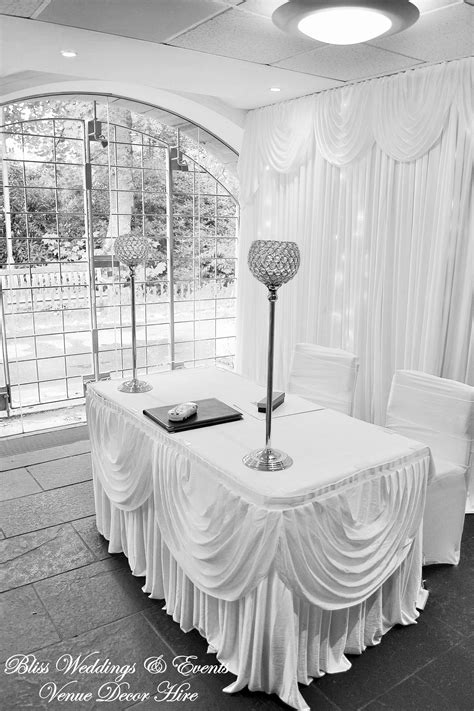 The Table Is Set Up For A Wedding Reception With White Drapes And