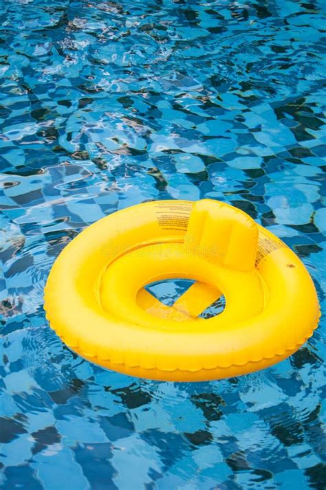 Floating Yellow Ring On Blue Water Swimpool With Waves Reflecting In