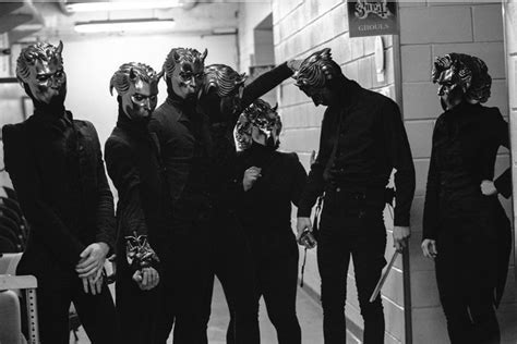 Five People In Masks Standing Next To Each Other
