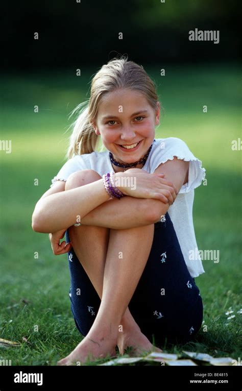 Happy Preteen Girl Sitting On Green Lawn Stock Photo Alamy