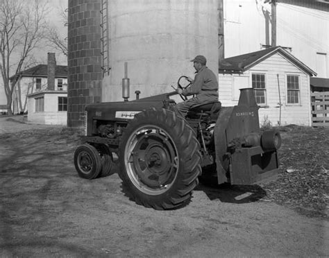 Farmer With Farmall Tractor And Attached Ensilage Blower