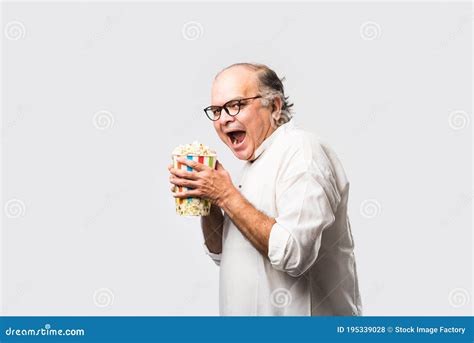 Indian Asian Old Man Eating Popcorn From Box Or Container Stock Photo