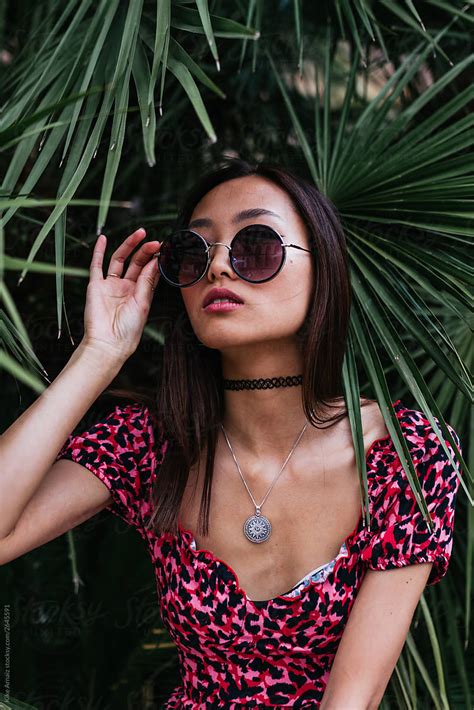 Portrait Of An Asian Woman Wearing Sunglasses And Palm Tree Background Del Colaborador De