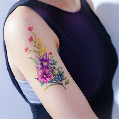 A Woman With A Flower Tattoo On Her Arm