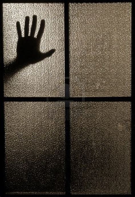 slightly blurred silhouette of a hand behind a window or glass glass photography window