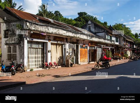 Homes and motorcycles parked on Sisavang Vong Road; Luang Prabang ...