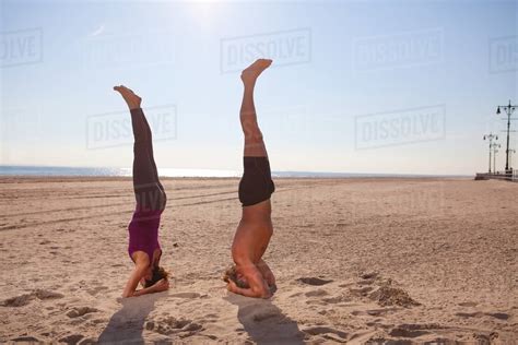 Woman And Man Performing Handstands On Beach Stock Photo Dissolve