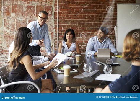 Businesspeople Meeting In Modern Boardroom Through Glass Stock Photo