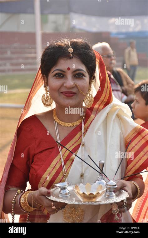 a bengali hindu lady poses as puja attitude with period costume and cultural period pieces at