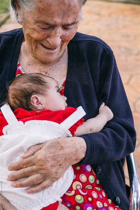 Great Grandmother Smiling With Her Grandbabe On Her Arms Senior Woman With A Baby By