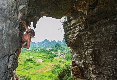 Male Climber At Treasure Cave In Yangshuo Guangxi Zhuang China