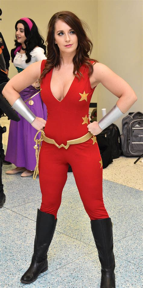 A Woman In A Red And Gold Costume Posing For The Camera With Her Hands On Her Hips