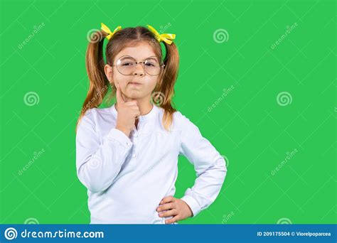 A Pensive Girl With Ponytails And Glasses Holds Her Hand To Her Face