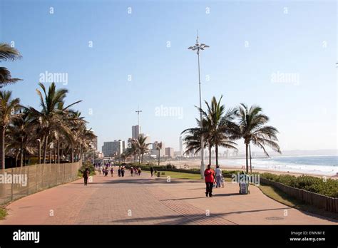 Many Unknown People Walk Along Paved Promenade On Golden Mile Beach