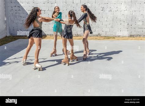 Four Latina Teenage Girls Dancing On Four Wheel Skates Making A Circle Or Playing A Round