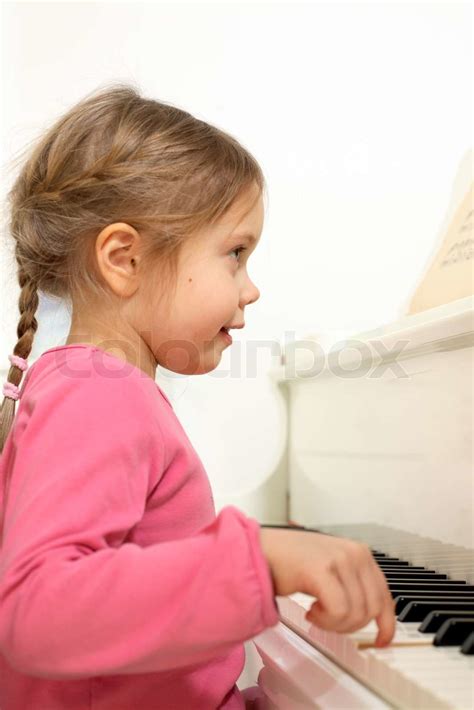 Profile Portrait Of Little Adorable Girl Playing The Piano Stock