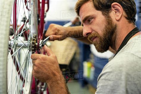 Mechanic Repairing Bicycle Wheel In Workshop Stock Photo Dissolve