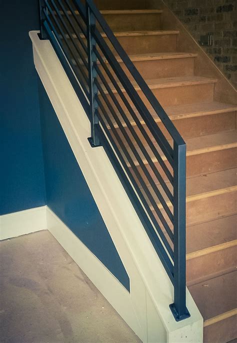 There Is A Black And White Stair Railing On The Side Of A Blue Wall