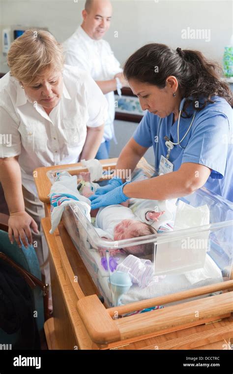 Nurse Changing Diapers To Newborn In Hospital Room While Grandmother