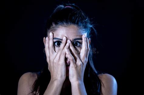 Scared Woman Covering Her Face With Hands Looking Through Her Fingers