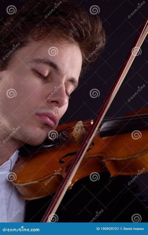 A Sad Violinist Plays A Violin On A Dark Background Stock Image Image
