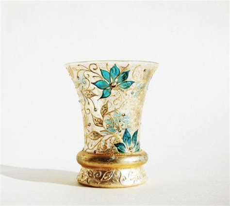 A Gold And Blue Vase Sitting On Top Of A White Table