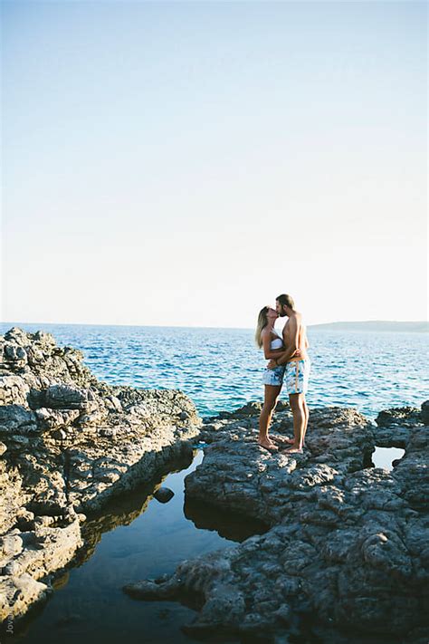 Young Couple Are Kissing On A Rock By Jovana Rikalo Stocksy United