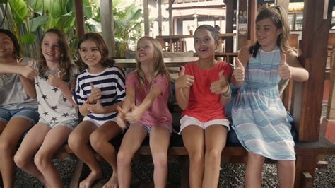 Diverse Group Of Happy Young Girls Giving The Thumbs Up And Chair