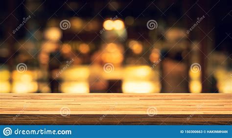 Wood Texture Table Top Counter Bar With Blur Light Gold Bokeh In Cafe