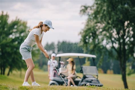 Selective Focus Of Woman With Golf Club Playing Golf And Friends