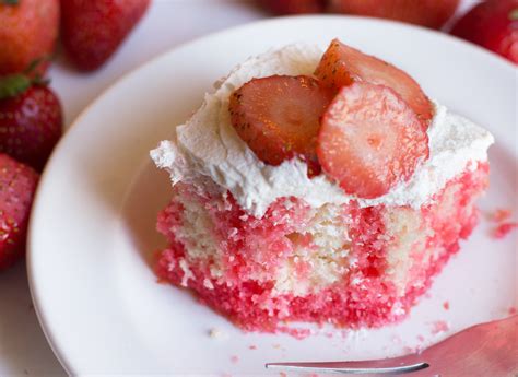 This white cake is filled with strawberry jello and topped with fresh whipped cream and strawberries. Strawberry Jello Cake - Sugar n' Spice Gals