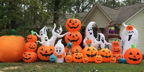 A Group Of Pumpkins And Ghost Balloons In Front Of A House