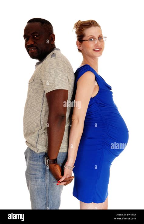 an african american man and his caucasian pregnant wife standing back to back isolated for