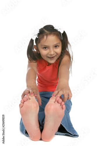 Cute Ponytailed Girl Touching Bare Feet Stock Photo And Royalty Free