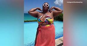 Lizzo Beeating shows of colorful swimsuit on tropical vacation