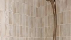 Create your own custom design by mixing tile shapes and patterns. In this shower, the Penny Round White mosaic complements its surrounding vertically stacked subway to showcase a uniquely modern and inviting space by @prairie.homes. | The Tile Shop