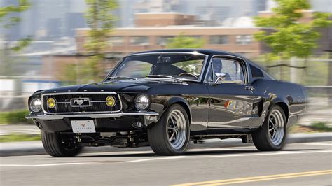 A 1967 Ford Mustang cruising on a scenic coastal road