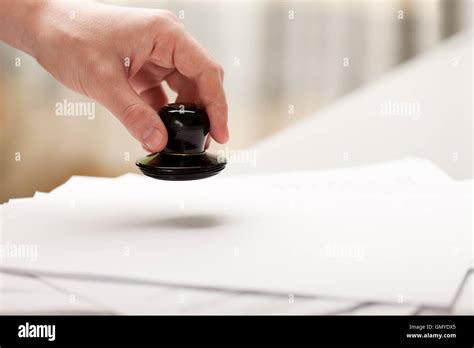 A hand giving a document with a stamp