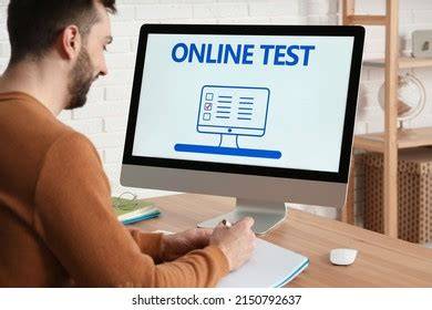 Man sitting at desk taking test on computer