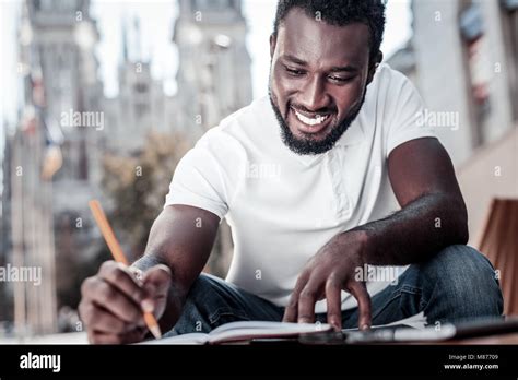 Person smiling while writing a letter