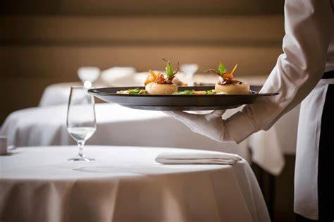 Professional waiter serving dishes