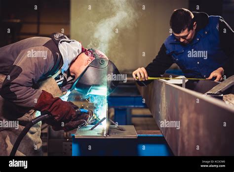 Welder checking blueprints