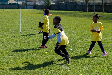 Anak-anak bermain rounders dengan gembira