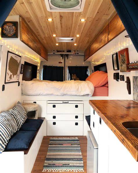 Neatly organized interior of a Ford Transit Connect camper with a bed and storage compartments