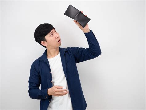 man looking sadly in wallet
