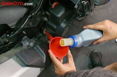 mengisi oli motor