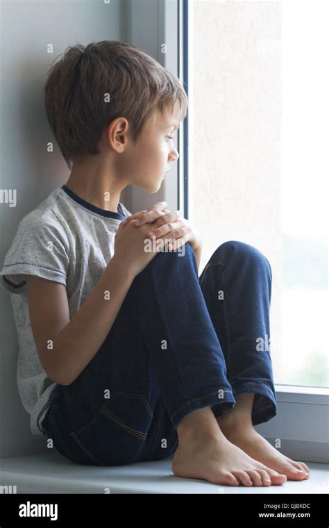 sad child looking out window