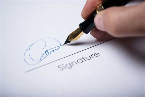 A person's hand signing a document