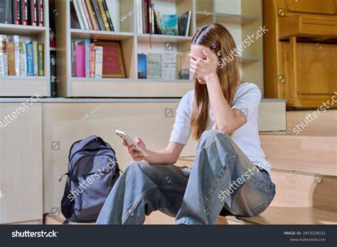student looking at phone sadly
